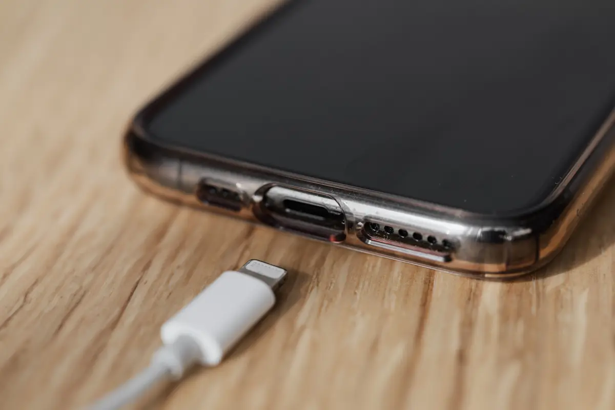 Close-up of a charging cable about to be plugged into the bottom of a phone in a clear case